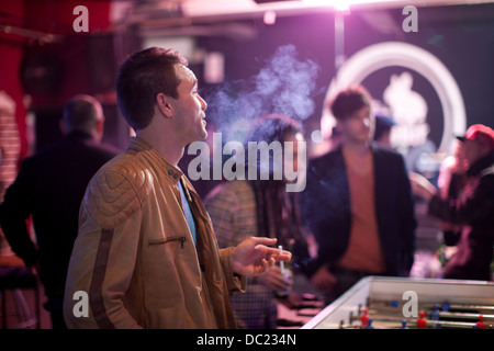 Uomo di fumare sigarette in bar Foto Stock