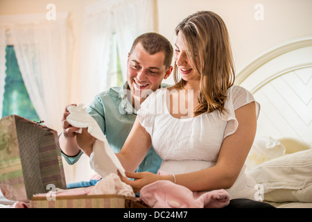 Giovane guardando attraverso il caso di vestiti del bambino Foto Stock