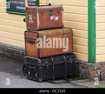 Carrello caricato con bagaglio vintage su una piattaforma della stazione Foto Stock