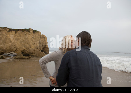 Coppia matura baciare sulla spiaggia Foto Stock