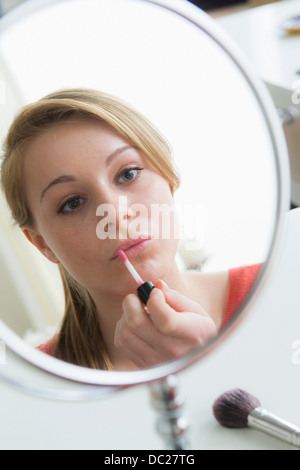 Ragazza adolescente applicando lip gloss Foto Stock