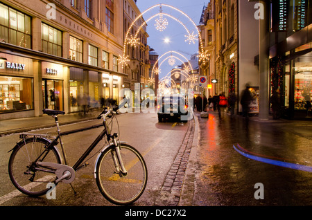 La Svizzera, Basilea. Holiday Lights su Freie Strasse, vicino Munsterplatz, Su occupato notte d'inverno. Foto Stock