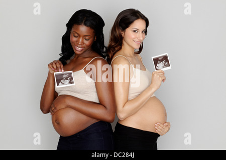 Due donne in stato di gravidanza azienda scansioni ad ultrasuoni Foto Stock