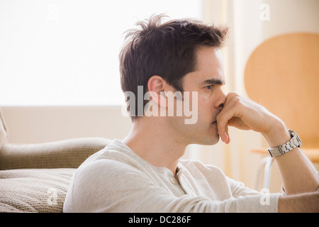 Metà uomo adulto con la mano sul mento Foto Stock