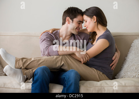 Matura sul divano, donna seduta sull uomo di giro Foto Stock