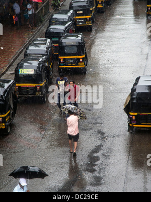 Piogge monsoniche risciò motorizzati Mumbai a piedi Foto Stock