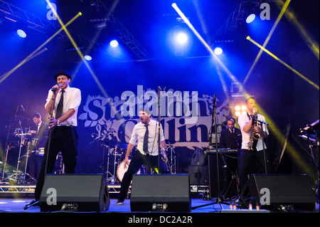 Hertfordshire, Regno Unito, 04/08/2013 : Standon Calling Festival. Sciur Dub Club gioca il palco principale. La band ha avuto origine in Leeds e consiste di: Jonathan Scratchley (voce), Toby Davies (bass chitarra, tastiere, voce), Kola Bello (tastiere e voci), Matt Roberts (tromba), Kieren Gallager (sax alto), Nick Tyson (chitarra), Niall Lavell (percussioni, campioni), Tommy Evans (tamburi),Harry Devenish (ingegnere). Foto di Julie Edwards Foto Stock