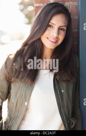 Ritratto di giovane donna con capelli lunghi marrone, sorridente Foto Stock