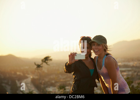 Donne auto-fotografare contro scenario Foto Stock