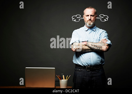 Uomo con le braccia incrociate fumante in silenzio Foto Stock