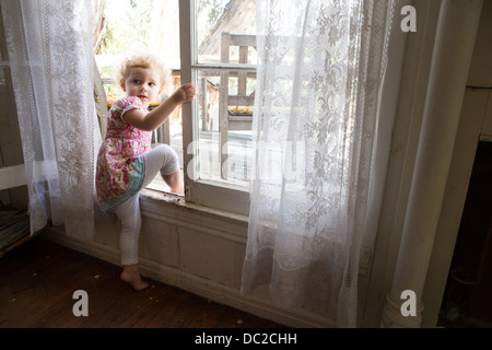 Il bambino che si arrampica sul finestrino aperto Foto Stock