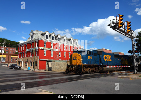 CSX treno diesel numero 8749 sulla ex Baltimore e Ohio Railroad passando lo sconto negozio di liquori, Cumberland, Maryland , USA Foto Stock