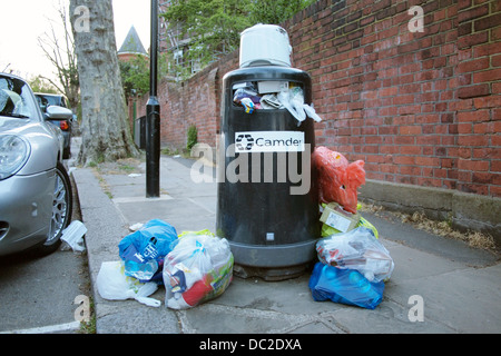 Traboccante bidoni della spazzatura in una strada residenziale a Londra Regno Unito Foto Stock