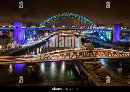 Fiume Tyne ponti in/Newcastle Gateshead prese su una lunga esposizione di notte che mostra i ponti illuminati a colori Foto Stock