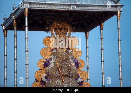 L'immagine della Madonna di El Rocio viene portata in processione in El Rocio village, in Almonte, parco nazionale di Donana, Spagna Foto Stock