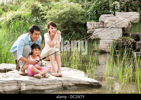 Allegro famiglia cinese la pesca in un parco Foto Stock