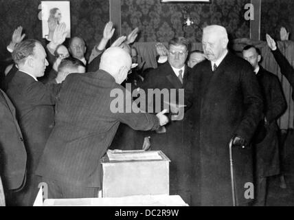 Il presidente del Reich Paul von Hindenburg (r) e il segretario di Stato otto Meissner (a sinistra, accanto a Hindenburg) sono raffigurati al ballottaggio di Berlino, in Germania, mentre il voto è espresso sotto il saluto nazista durante le elezioni tedesche del 12 novembre 1933. Fotoarchiv für Zeitgeschichte Foto Stock