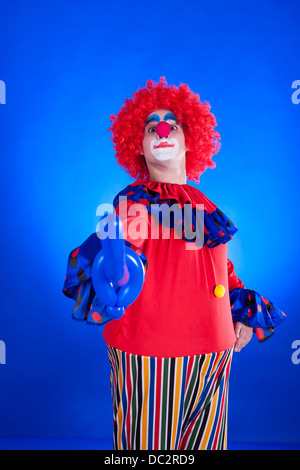 Clown su sfondo blu all'interno di studio shot Foto Stock