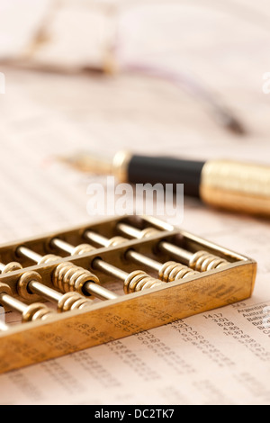 Abacus e penna a sfera su scrivania Foto Stock