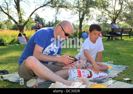 Padre e figlio nel parco con un giocattolo telecomando barca. Foto Stock