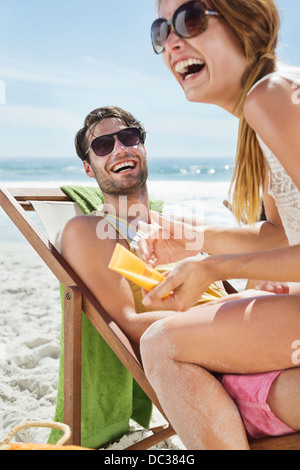 Coppia felice con sunscreen presso la spiaggia Foto Stock