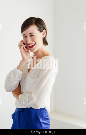 Ridendo donna parlando al cellulare Foto Stock