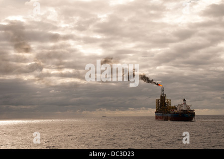 L'utilizzo di una FPSO oil rig fino all'orizzonte nel settore offshore, inviando il fumo in atmosfera. Foto Stock