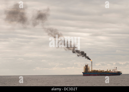 L'utilizzo di una FPSO oil rig fino all'orizzonte nel settore offshore, inviando il fumo in atmosfera. Foto Stock