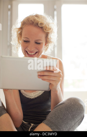 Donna sorridente con tavoletta digitale Foto Stock