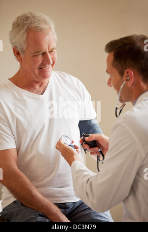 Controllo medico senior il sangue dell'uomo pressione nell'ufficio del medico Foto Stock