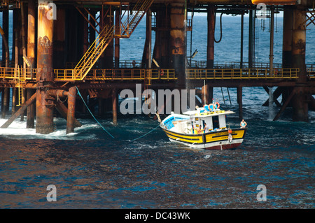 Piccola pesca barca ormeggiata su offshore Oil Rig PCH-01, lavorando per Petrobras, Campos Basin, Rio de Janeiro, Brasile Foto Stock