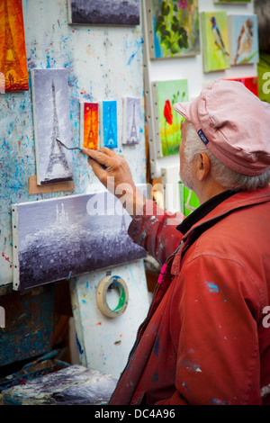 Artista aggiunta la Torre Eiffel per la sua pittura in Place de Tertre a Montmartre, Parigi Francia Foto Stock