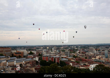 Una massa di aria calda palloncini dal 2013 Bristol Balloon Fiesta galleggiante passato Cabot Tower la sera Foto Stock