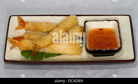 Autentici piatti Giapponesi fotografati con un contemporaneo stile americano. Una piastra di croccante di gamberi fritti con salsa e baguette Foto Stock