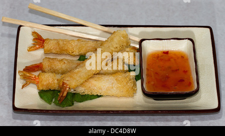 Autentici piatti Giapponesi fotografati con un contemporaneo stile americano. Una piastra di croccante di gamberi fritti con salsa e baguette Foto Stock