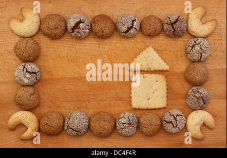 Cioccolato, zenzero e nocciola cookies telaio su tavola di legno con casa segno, spazio di copia Foto Stock