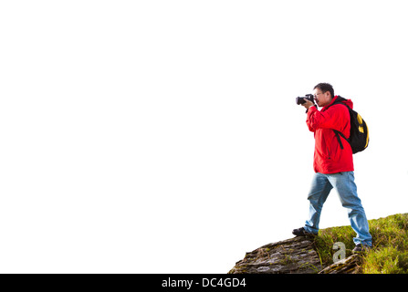 Fotografo in piedi sulla cima del monte isolato su bianco Foto Stock