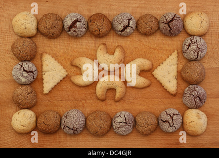 Cioccolato, zenzero e nocciola cookies telaio su tavola di legno con impilamento ornamento dei cookie Foto Stock