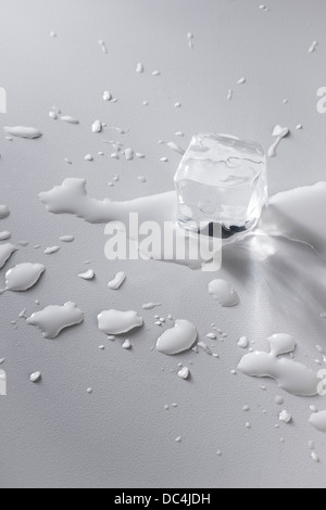 Il cubo di ghiaccio la fusione con pozzanghere di acqua Foto Stock