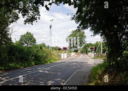 Passaggio a livello ferroviario nelle zone rurali campagna inglese, con barriere chiuse Foto Stock