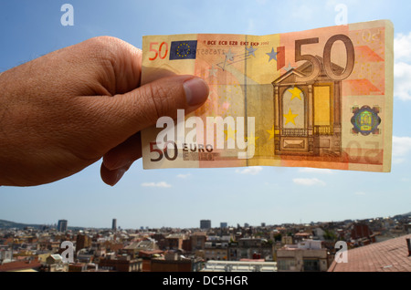 Mano che tiene una cinquantina di banconote in euro Foto Stock
