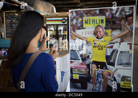 L'uomo ha il suo vincitore del Tour de France maglia gialla foto scattata al "Guarda mamma senza mani " Ciclismo cafè sulla Southbank. South Bank è una significativa delle arti e il quartiere del divertimento, Riverside marciapiede affollati di visitatori e turisti. Londra, Regno Unito. Foto Stock