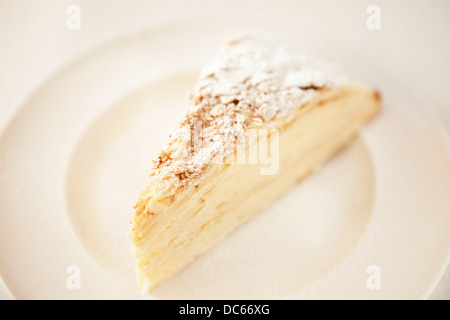 Napoleone torta sul piatto bianco e tovaglia bianca Foto Stock