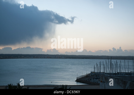 Il cloud con pioggia spazzare fuori al mare in una mattinata invernale in febbraio, Can Pastilla, Maiorca, Spagna. Foto Stock