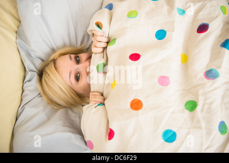 Giovane donna giaceva a letto Foto Stock