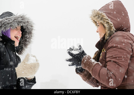 Due giovani donne aventi snowball volo Foto Stock