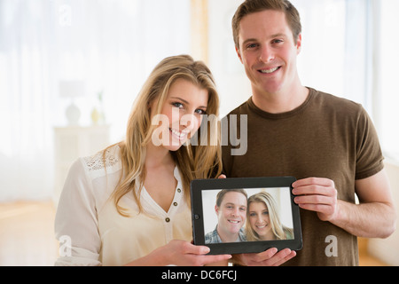 Ritratto di coppia giovane mantenendo le loro foto Foto Stock