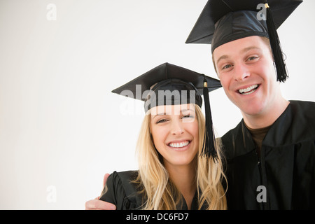Coppia di amici in abiti di graduazione Foto Stock