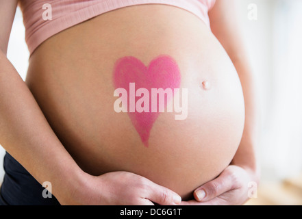 La sezione centrale della donna incinta con il disegno del cuore sulla pancia Foto Stock