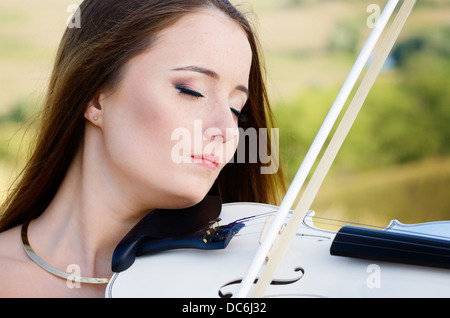 Giovani belle violin player con fiddle bianco Foto Stock